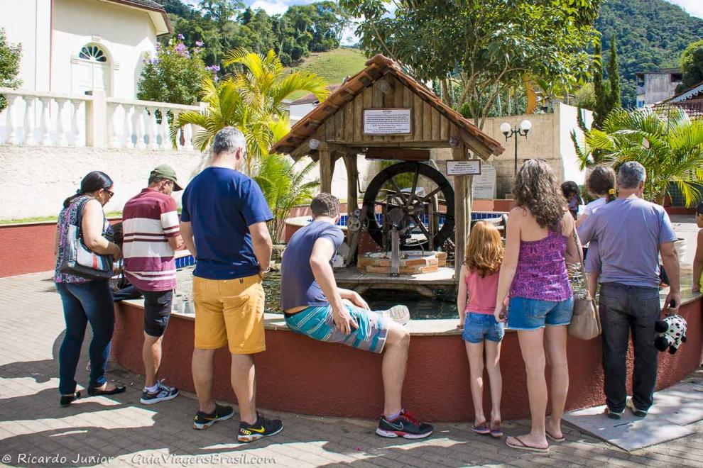 Imagem de turistas vendo a fonte da cidade de Domingos Martins.